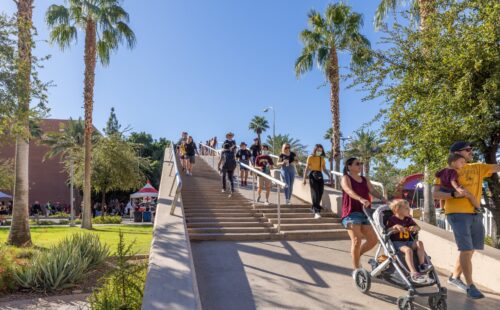Families with strollers and other groups of people walking down the ASU bridge