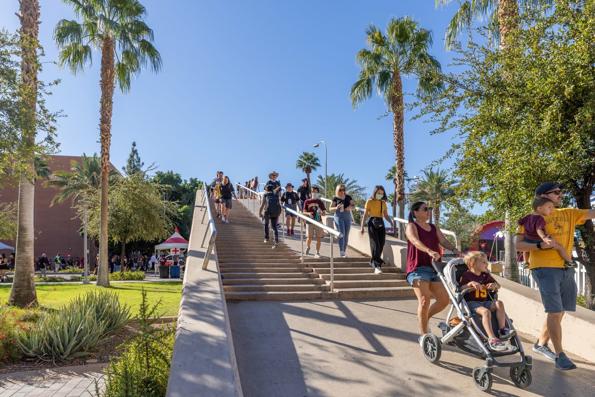 Families with strollers and other groups of people walking down the ASU bridge