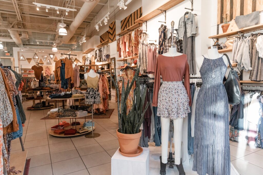 A display of dresses, pants and clothes on a mannequin at the front of the store