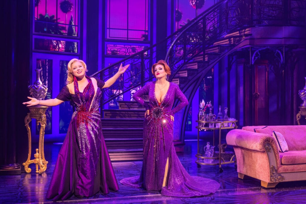Two women in purple dresses on stage