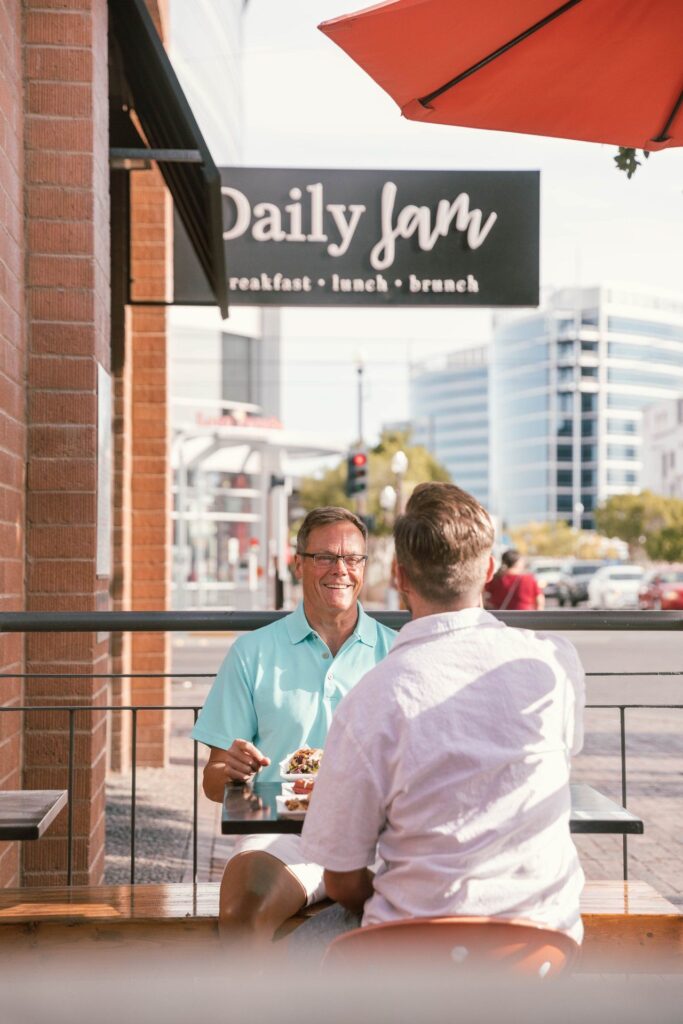 A man smiling at his partner at the Daily Jam patio