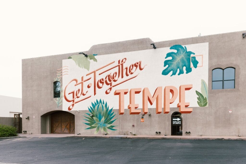 A large wall with "Get Together Tempe" painted with leaves around it