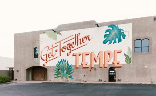 A large wall with "Get Together Tempe" painted with leaves around it
