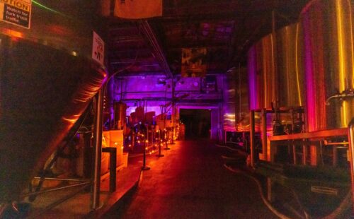 Four Peaks Brewery at night with orange lights along the side and purple lights