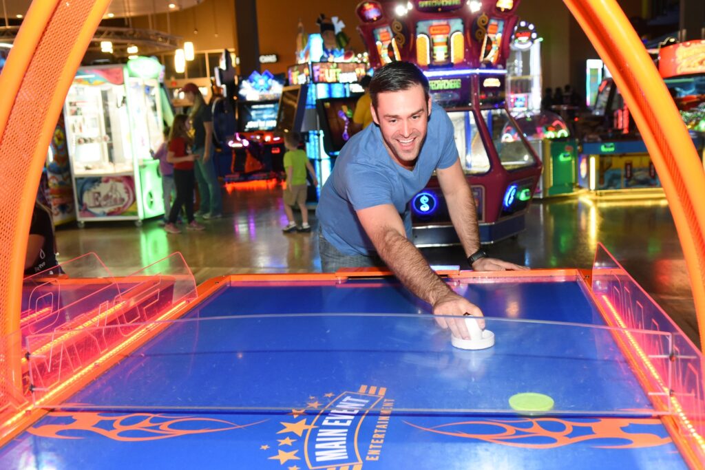 Main Event_male playing Air Hockey