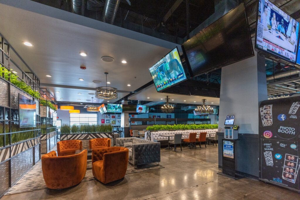 A wide shot of a bar with couches and TV hanging on walls