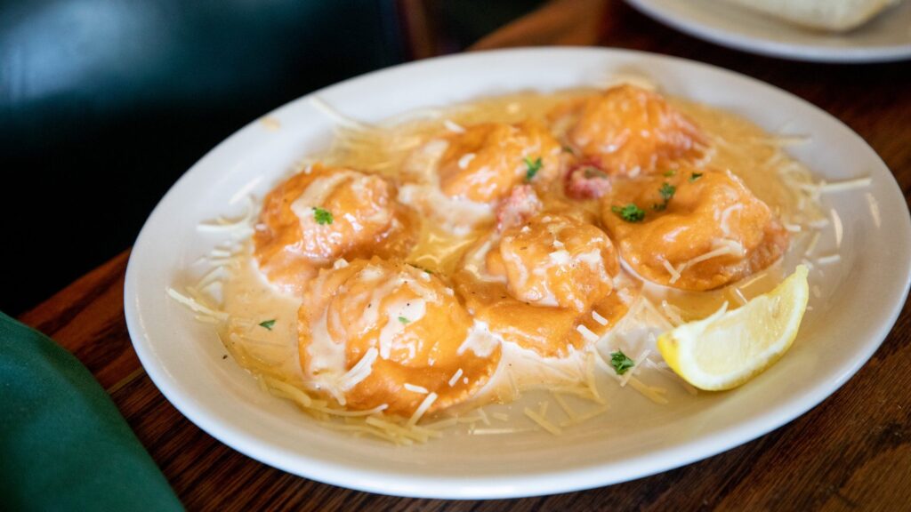 A plate of cheese ravioli with tomato cream sauce