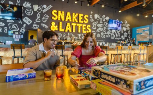 Two friends playing board games and eating