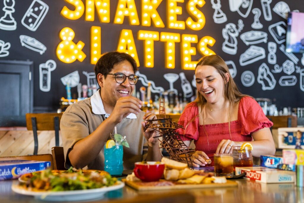 Two friends playing board games and eating food