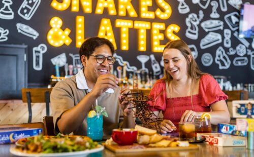 Two friends playing board games and eating food